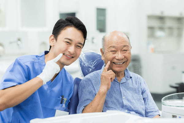 pixta_59566461_M_歯科医師と高齢の男性患者
